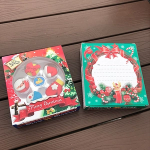 Close-up of Santa Claus themed stationery gift boxes on a dark wooden surface