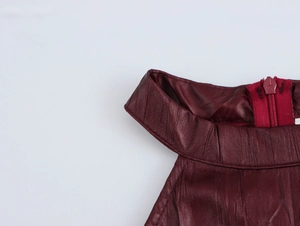 Dettaglio dell'abito in pelle PU rosso scuro con cerniera posteriore e scollo all'americana