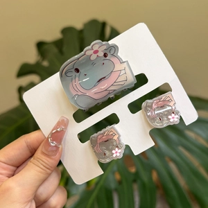 Detailed view of acrylic hippo hair clips and claw clip set on white display card