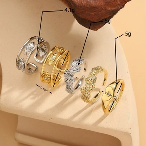 Stack of gold and silver evil eye rings with heart and star patterns on beige display
