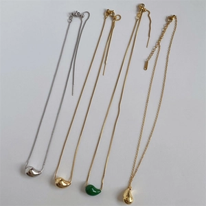 Polished teardrop pendant necklaces in gold and silver finish on white background