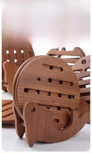 Detailed view of an ebony wood whale-shaped base with circular heat-resistant pads