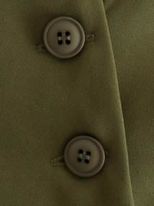 Macro detail of asymmetric vest with military green twill fabric and dark brown resin buttons