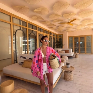 Pink oversized embroidered cardigan for women styled with boho beach vacation accessories