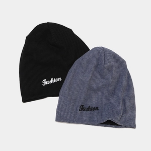 Détail du tricot gaufré et de la broderie Fashion sur les bonnets noir et bleu