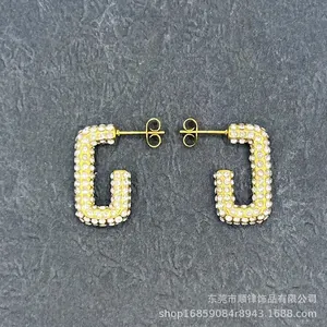 Detailed view of gold rectangle hoop earrings with pave-set shimmering crystals