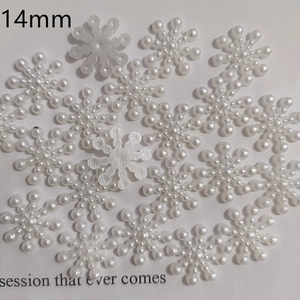 Close-up of 14mm white faux pearl snowflake flatback charms for DIY jewelry and nail art