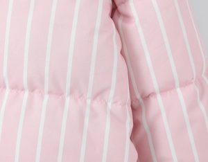 Detailed close-up of pink and white striped quilted texture on long sleeve hooded jacket