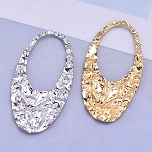 Irregular hollow oval pendant in gold and silver with unique hammered metal texture