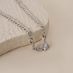 Silver NK chain necklace featuring two marquise-cut zircons on a textured stone display