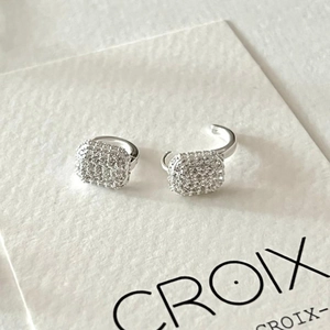 Macro shot of silver S925 earrings with pavé set zircons on white display card