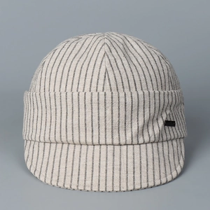 Detail showing natural cotton texture and vertical black stripes on a stylish newsboy cap