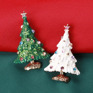 Detail of gold Christmas tree brooches with green sequins and white rhinestones