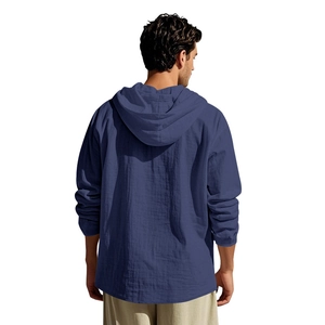 Back view of a men's loose fit blue hooded linen shirt with long sleeves on a model