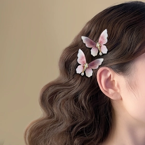Elegant butterfly hair clips with purple gradient wings and pearl drops on wavy hair