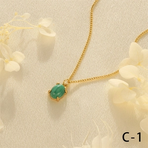Detail of green malachite pendant in 18K gold plated claw setting on silk texture