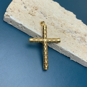 Macro shot of 18k gold cross pendant with hollow design and sparkling zircon stones