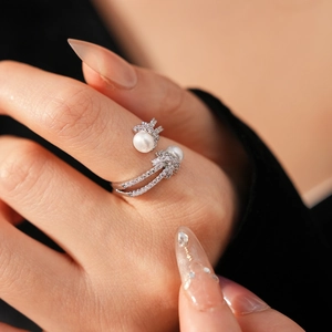Macro detail of knotted pearl ring with zircon accents in elegant silver finish