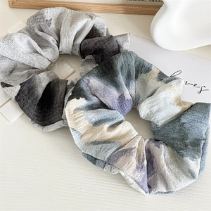 Détail de chouchous en tissu haute élasticité avec des motifs floraux élégants sur table