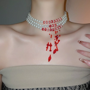 Close-up of triple-layer choker necklace with elegant white pearls and red beaded tassels