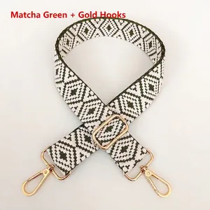 Detail of green and white geometric pattern woven bag strap with golden metal hooks