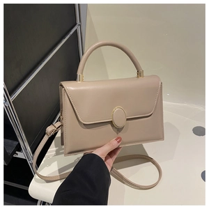 Détail du sac à main beige en similicuir avec boucle dorée et coutures précises