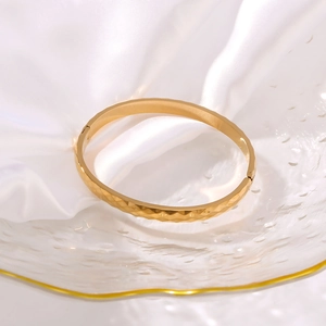 Bracciale rigido in acciaio al titanio dorato 18K con trama a onde geometriche lucide