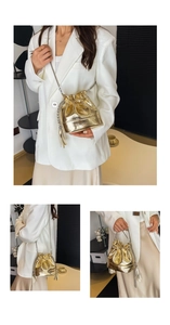 Detail of golden bucket bag showing shiny leather texture, metal chain, and tassels