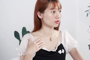Detailed view of an elegant gold leaf necklace and earrings set worn by a model