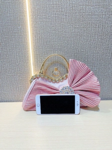 Pink pleated evening clutch with rhinestone handle and phone for size reference