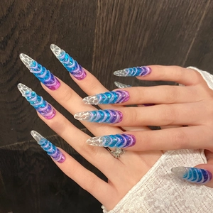 Long stiletto press-on nails with blue-purple 3D spiral texture and clear crystal tips