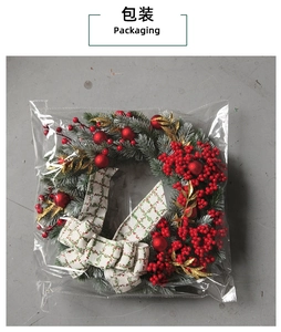 Detailed packaging view of a Christmas berry wreath with pine needles and plaid bow