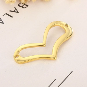 Détail macro d'un connecteur de bijoux doré en forme de cœur pour bijoux DIY