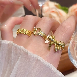 Close-up of elegant 18k gold plated rings with bow and horseshoe cubic zirconia designs