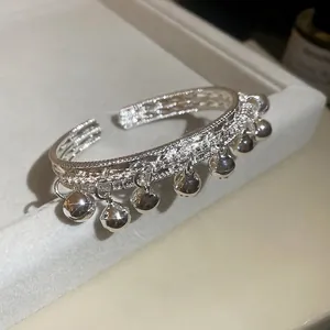 Bracelet jonc ouvert en argent élégant avec clochettes pendantes et texture tressée