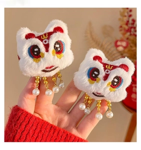 Close-up of plush Lion Dance hair clips with golden chains and elegant white pearls