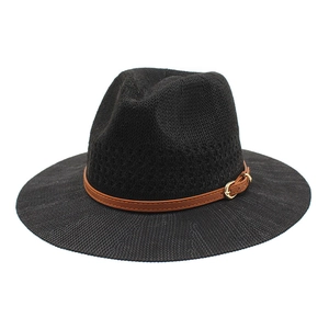 Close-up of black straw fedora hat featuring breathable woven texture and brown leather strap