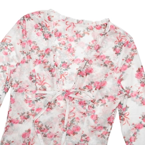 Détail de la robe en tulle blanc à fleurs roses avec col en V et laçage à l'avant