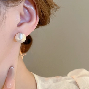 Close-up of model wearing white brushed texture sphere stud earring with matte finish