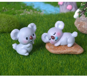Nahaufnahme von zwei Mini-Koalas aus grauem Harz auf Moos für DIY-Mikrolandschaften