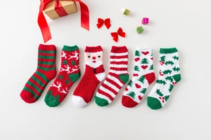 Close-up of 6-pack Christmas coral fleece socks with reindeer and Santa patterns in a gift box