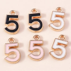 Détail de pendentifs chiffre 5 en alliage avec émail coloré en noir blanc et rose pastel