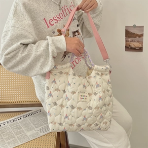 Vue détaillée d'un sac matelassé ivoire avec motif éléphant et bandoulière rose réglable