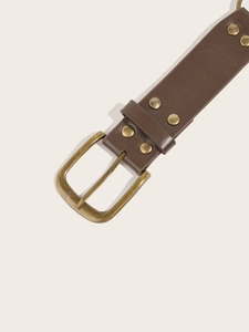 Close-up of brown leather belt with vintage bronze pin buckle and stud details