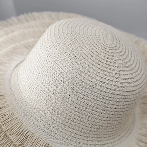 Detailansicht beige Strohhut mit aufwendiger Webstruktur und ausgefranster Quastenkante