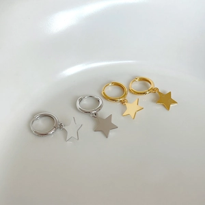 Close-up of minimalist S925 silver and gold star pendant earrings on a white background