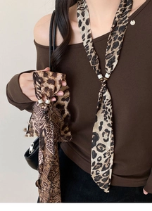 Detail eines Chiffon-Halstuchs mit Leopardenmuster, Metallschnalle und Perlen