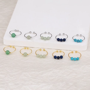 Detail of adjustable gold and silver rings set with colorful pearl-like beads