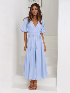 Detail of light blue V-neck maxi dress featuring puffy sleeves and tiered hem design