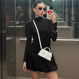 Gros plan d'une robe mini noire à manches longues avec un design d'ourlet à bulles